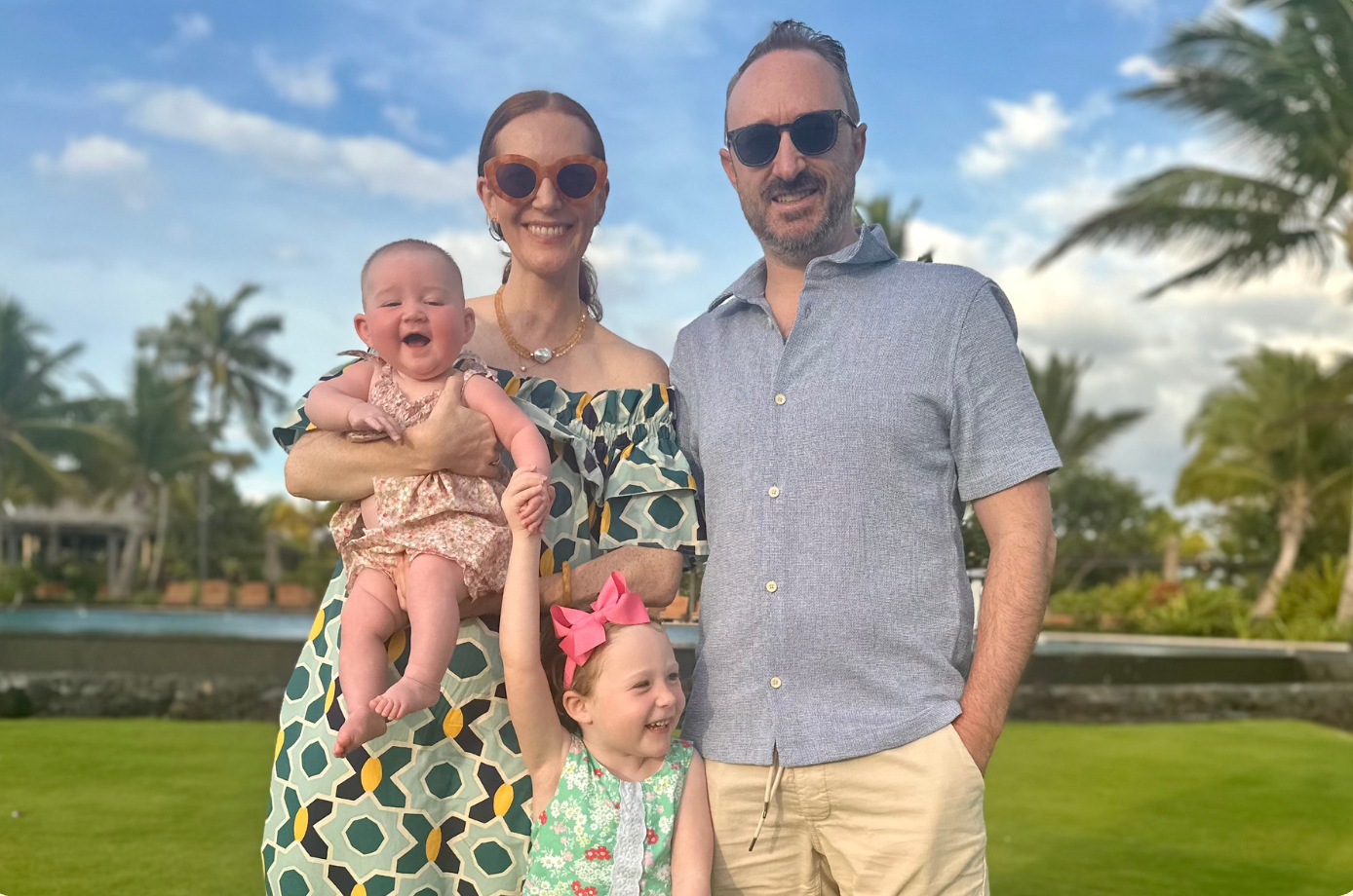 A family enjoys a relaxed outdoor meal together in the golden glow of a summer evening. 